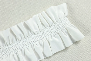Close-up of white ruched fabric detail and elastic texture on a backless A-line dress