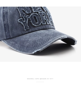 Detail shot of distressed brim and New York embroidery on navy blue baseball cap