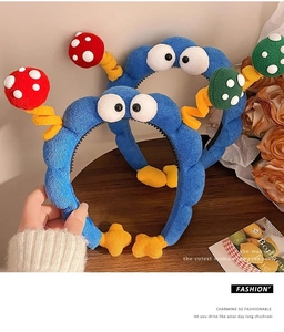 Detail showing plush blue headband with cartoon eyes and 3D mushroom spring decor