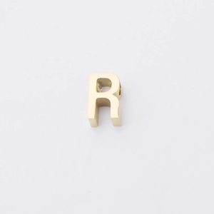 Macro shot of gold-plated stainless steel letter R bead with mirror polished finish