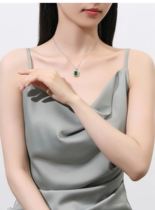 Detail of S925 silver necklace with emerald cut green pendant worn by a model
