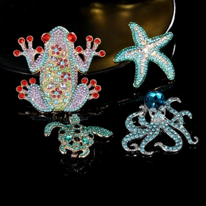 Sparkling marine animal brooches with colorful rhinestones on a black background
