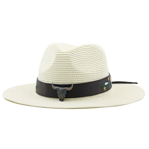 Dettaglio cappello di paglia crema con fascia in pelle, ricamo floreale e testa di toro