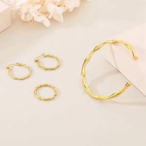 Detailed view of golden bamboo style jewelry set with bracelet, ring, and earrings