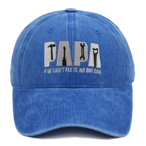 Close-up of PAPA embroidery and tool silhouettes on a blue washed cotton baseball cap