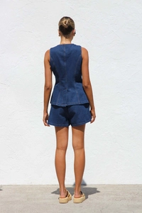 Vue arrière de l'ensemble en jean bleu foncé avec gilet sans manches et short taille haute