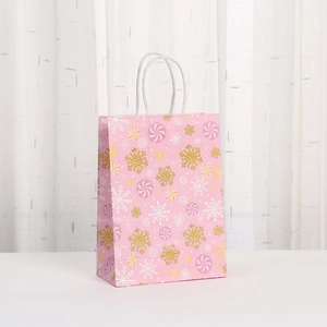 Pink Christmas kraft paper gift bag with glitter snowflakes and candy cane patterns