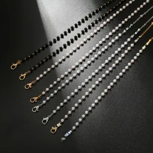 Detail of colorful beads and pearl eyeglass chains with lobster clasps on grey texture
