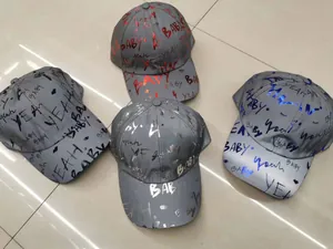 Detailed view of four reflective graffiti baseball caps with red, black, blue and silver prints