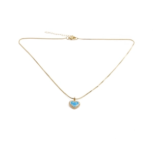Detailed macro view of gold heart pendant with blue enamel smiley face and micro-zirconia inlay