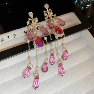 Detail of long fringe earrings with pink crystals and shimmering rhinestones