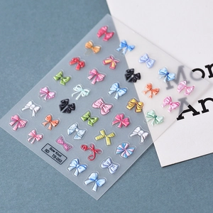 Detailed macro view of 5D embossed bow knot nail stickers with colorful textured patterns