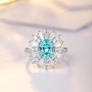 Macro view of oval light blue gemstone ring with sparkling diamond halo setting