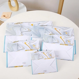 Elegant marble pattern paper gift bags with handles in various sizes for celebrations