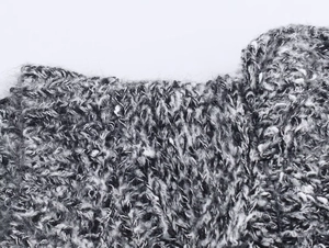 Gros plan sur la maille chinée noir et blanc aux fibres douces d'aspect mohair