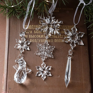 Clear acrylic Christmas tree ornaments with snowflake and icicle designs on pine branches