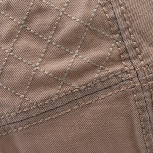 Close-up of khaki diamond quilted twill fabric with reinforced double-needle stitching
