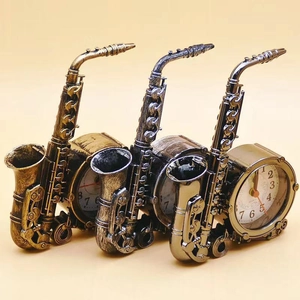 Detailed view of saxophone-shaped table clocks in bronze, antique silver, and bright silver