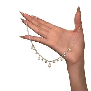 Elegant silver necklace featuring teardrop pearls and sparkling cubic zirconia pendants