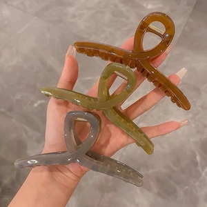 Detailed view of hair clips in amber brown, olive green, and smoke gray colors