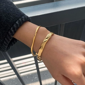 Stackable gold titanium steel bracelets with minimalist and wave textures on wrist