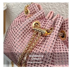 Detailed close-up of pink rhinestone bucket bag featuring a gold metal drawstring opening