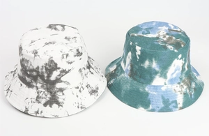 Detail of tie-dye bucket hats in black-white and blue-green colors with twill texture