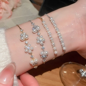 Detailed close-up of French-style floral pearl bracelets with sparkling zircon accents