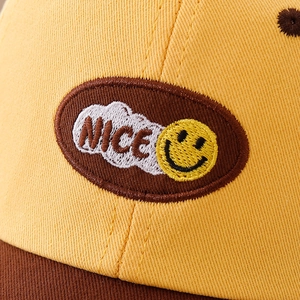 Berretto da baseball per bambini con patchwork giallo e marrone e smiley ricamato