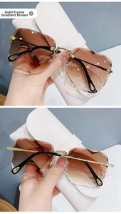Detailed view of rimless brown gradient sunglasses with gold metal textured temples