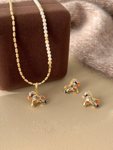 Close-up of gold-plated trojan horse pendant necklace with pearls and colorful zircons