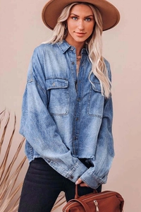Close-up of washed denim shirt featuring large flap pockets and vintage metal buttons