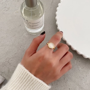 Close-up of a gold S925 silver ring with cat eye stone worn by a female model