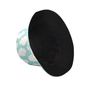Detail of reversible bucket hat showing blue sky cloud pattern and solid black inner side