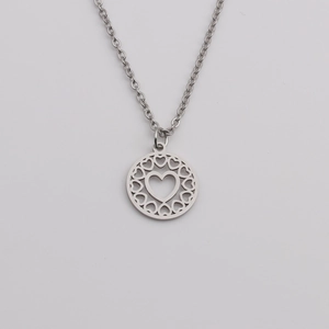 Minimalist silver stainless steel necklace with circular heart pendant on light gray background