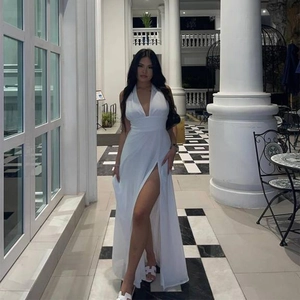 Detail of elegant white halter neck dress with deep V-neck and high side split feature