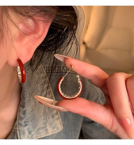 Detailed close-up of 14K gold plated hoop earring with red enamel and white crystals
