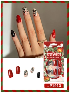 Macro detail of Christmas press-on nails with red glitter and festive fruit patterns