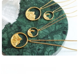 Detailed view of hollow mountain peak necklaces on green marble with premium gold finish