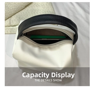 Detail view of white leather handbag interior showing large capacity with green smartphone