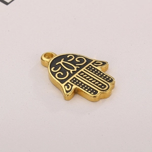 Golden Hamsa Hand pendant with black enamel evil eye detail and retro vintage patterns