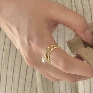 On-finger view of a minimalist S925 silver double-layered gold ring with a single pearl