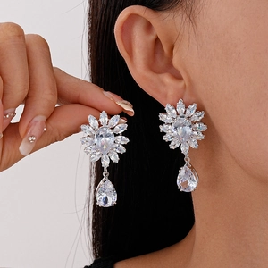 Boucles d'oreilles fleurs en argent et zircons portées par un mannequin élégant