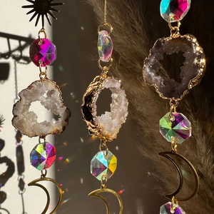 Close-up of golden moon sun catchers with natural quartz and rainbow crystal prisms