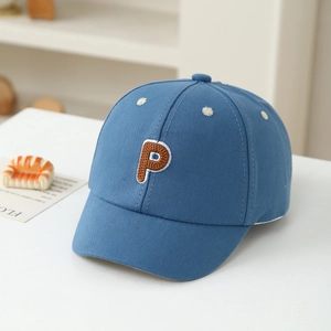 Detail of kids navy baseball cap with brown letter P embroidery on white table