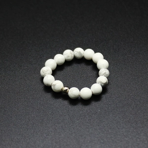 Macro shot of 4mm white stone elastic beaded ring with grey marble texture and silver bead