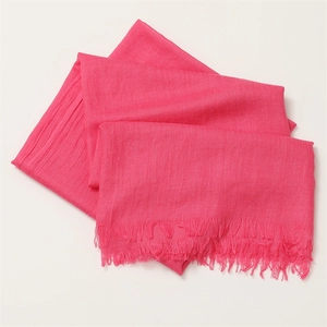 Detailed macro shot of the rose red linen scarf texture with soft fringe edges