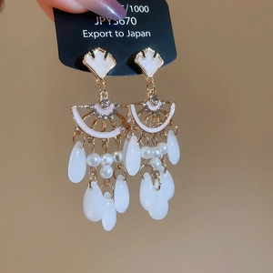 Close-up of vintage ginkgo leaf tassel earrings with white resin pearls and crystals