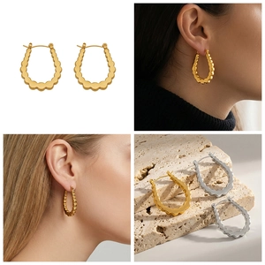U-shaped wavy thick hoop earrings in gold and silver finish on model and stone