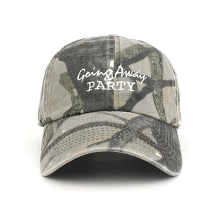 Detail of embroidered 'Going Away PARTY' text on camouflage washed cotton baseball cap